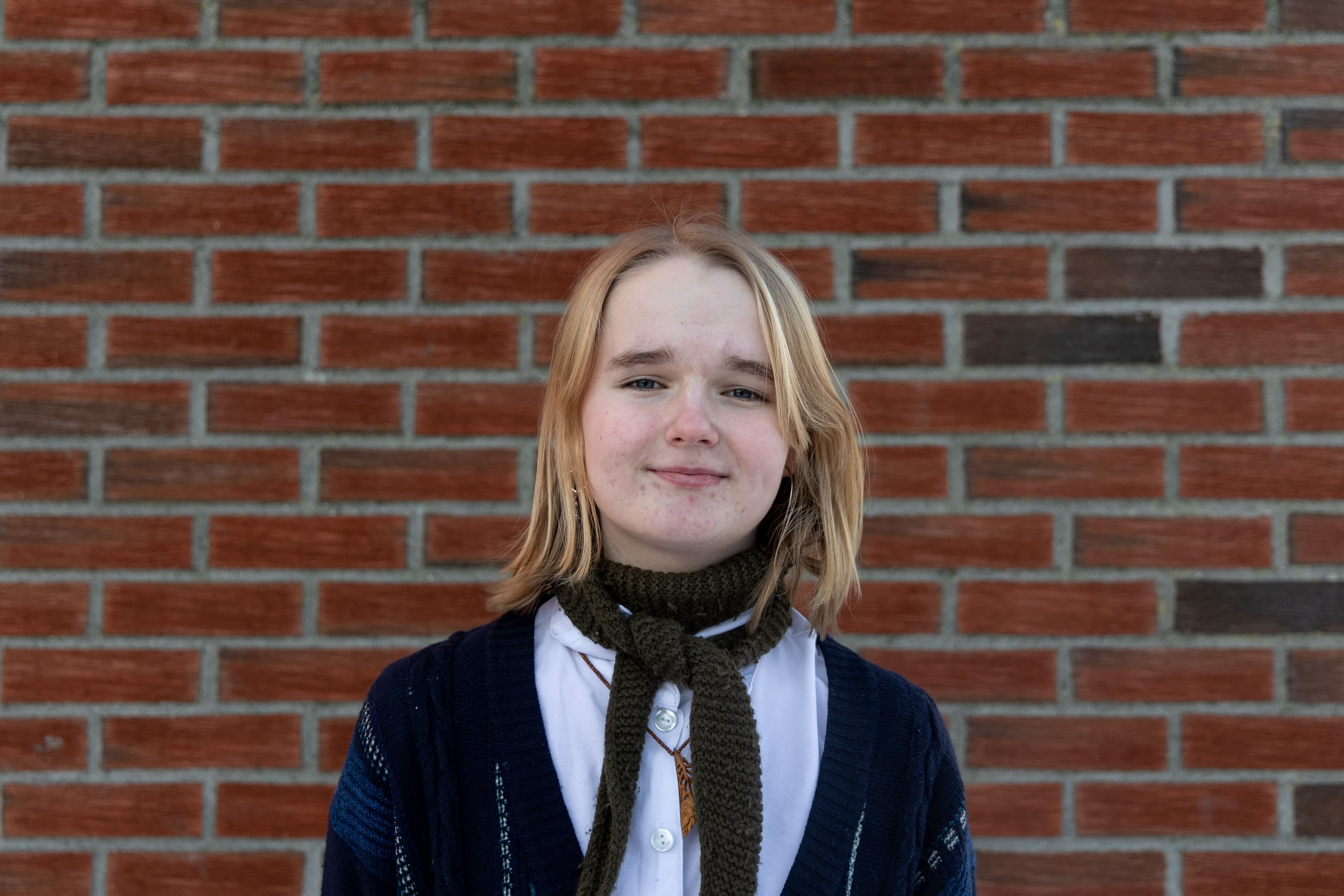 Portrett av Sine, med mur i bakgrunnen.