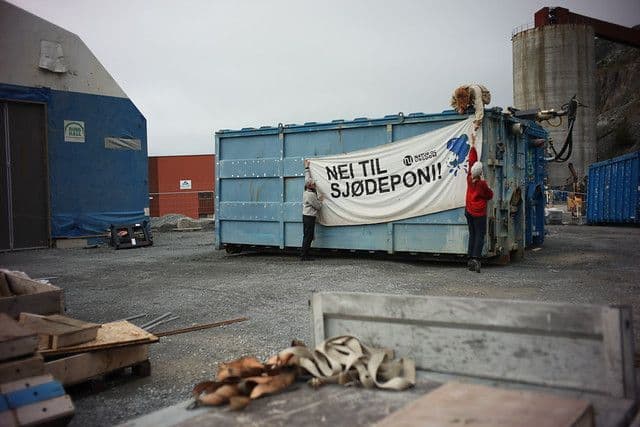 Bilde av aktivister som henger opp et "nei til sjødeponi" - banner