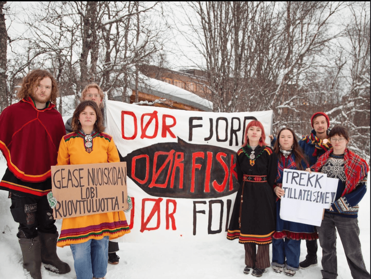 Aktivister i Tromsø med banner med teksten "Dør fjord, dør fisk, dør folk"