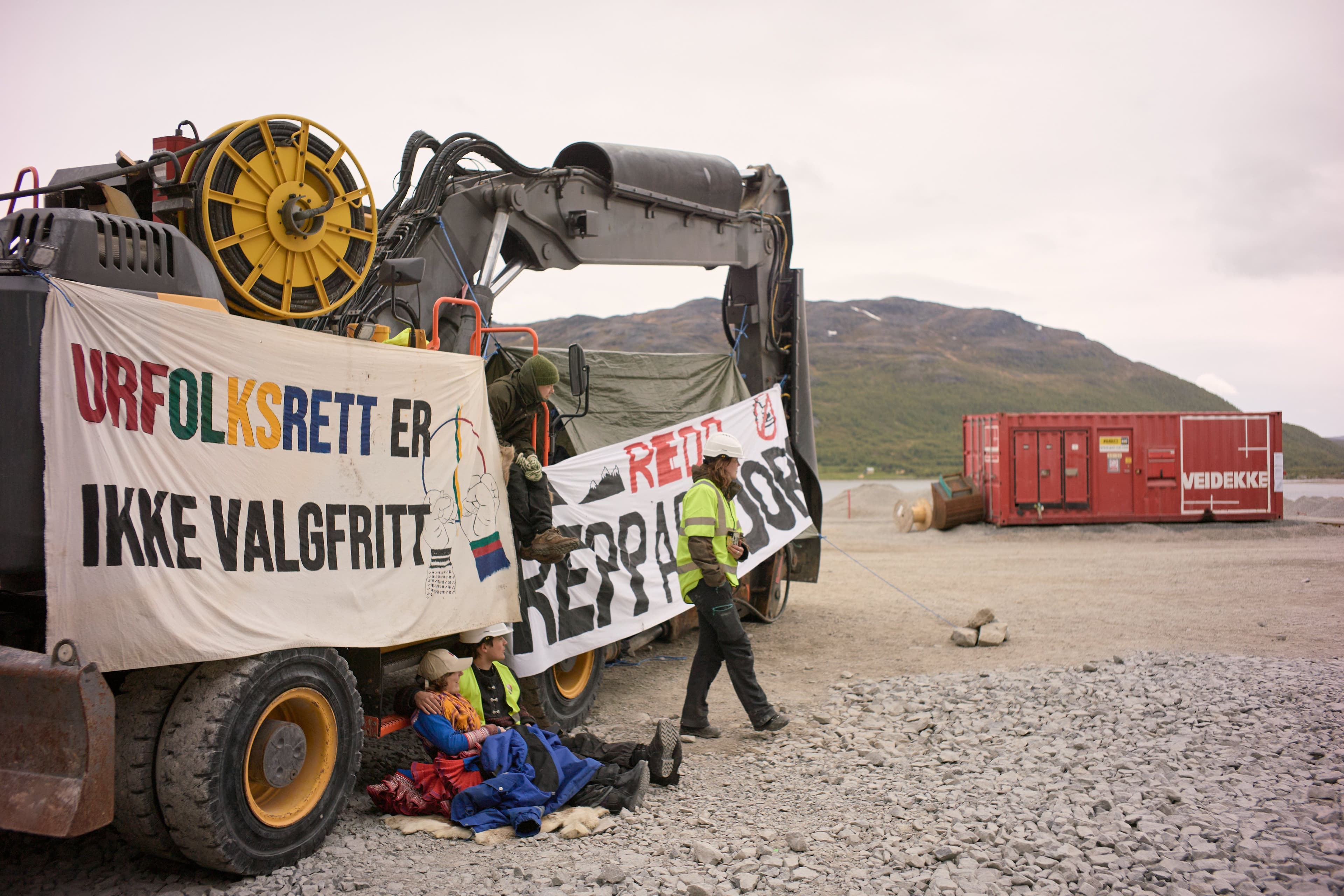 Aksjonister på en gravemaskin ved repparfjorden