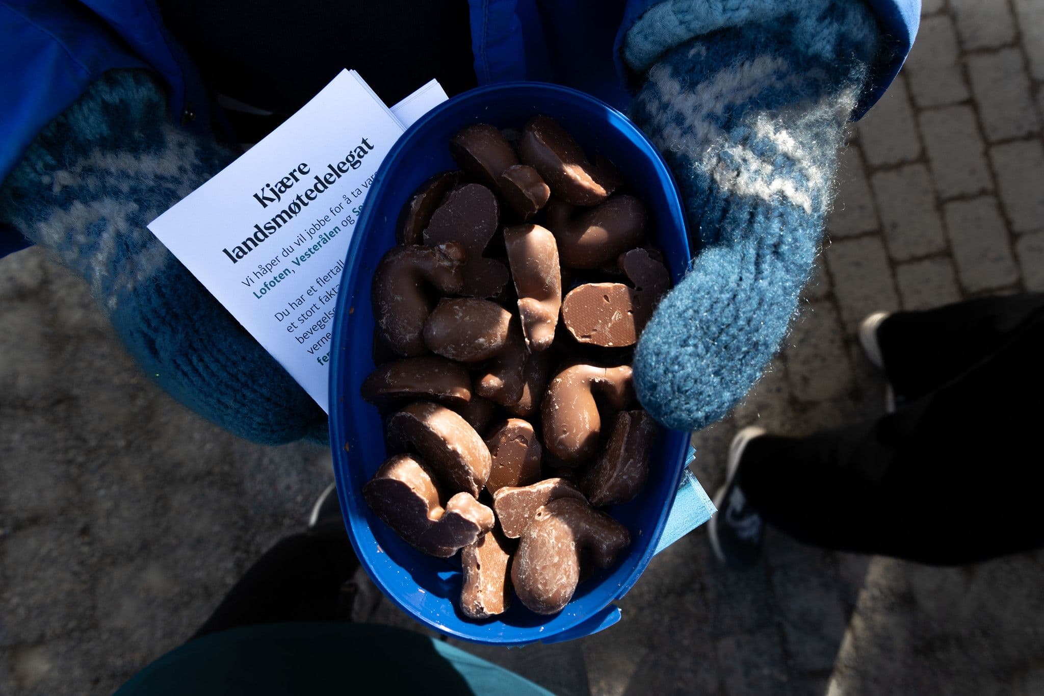 En som holder frem sjokolade og flyers
