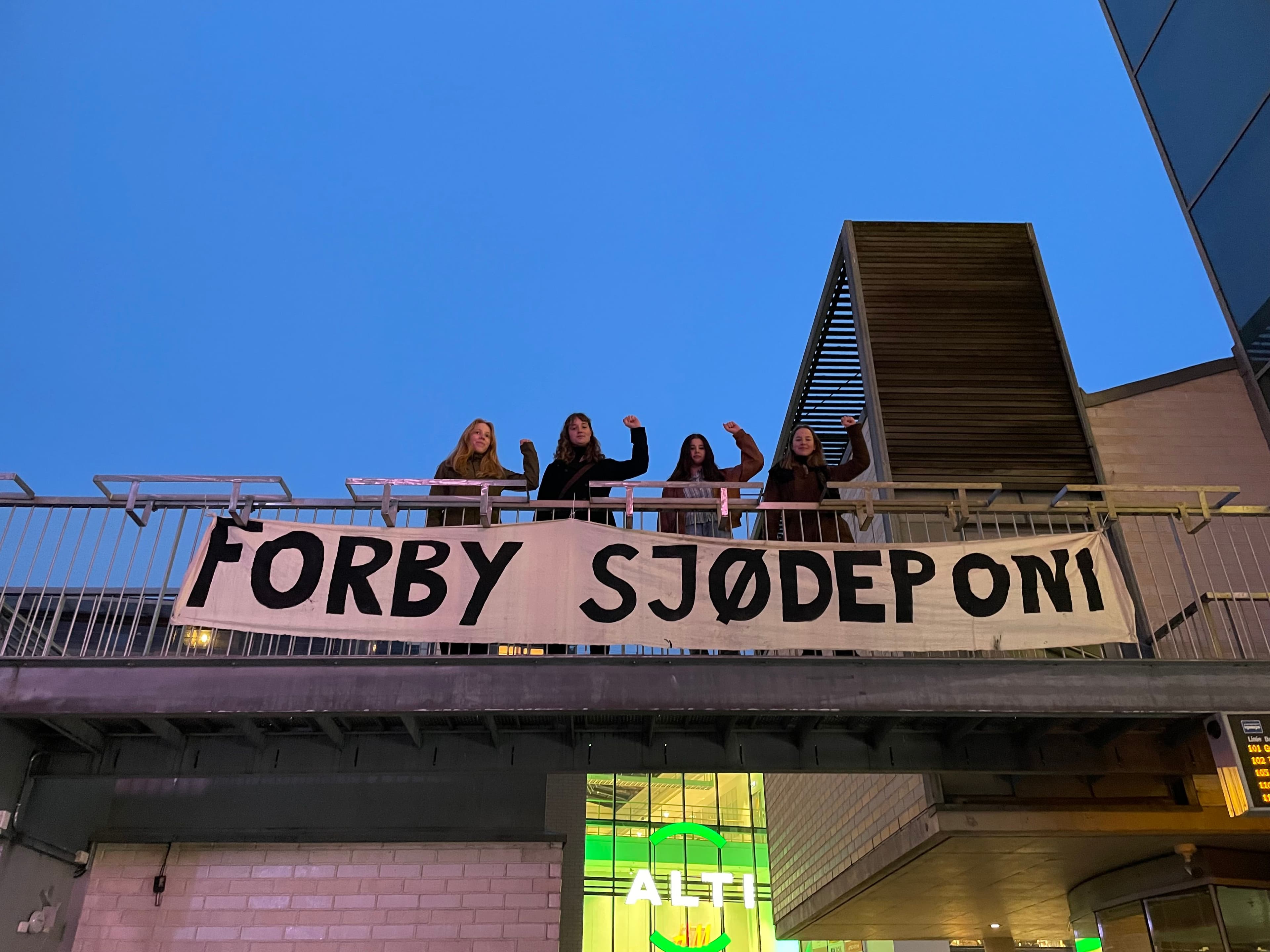 Bannerdrop med teksten "Forby sjødeponi" foran fire aktivister