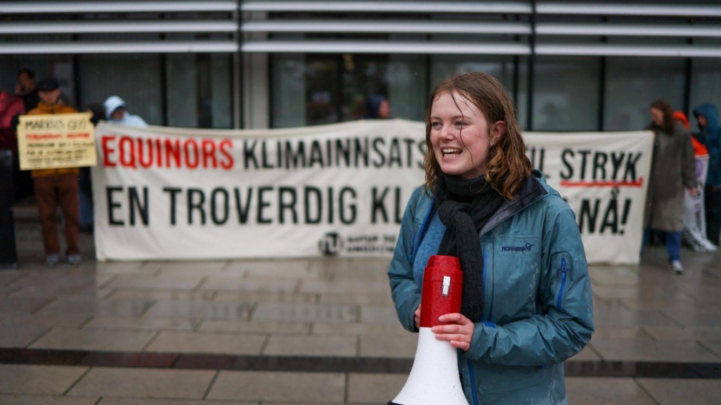 Aktivist med megafon foran et banner